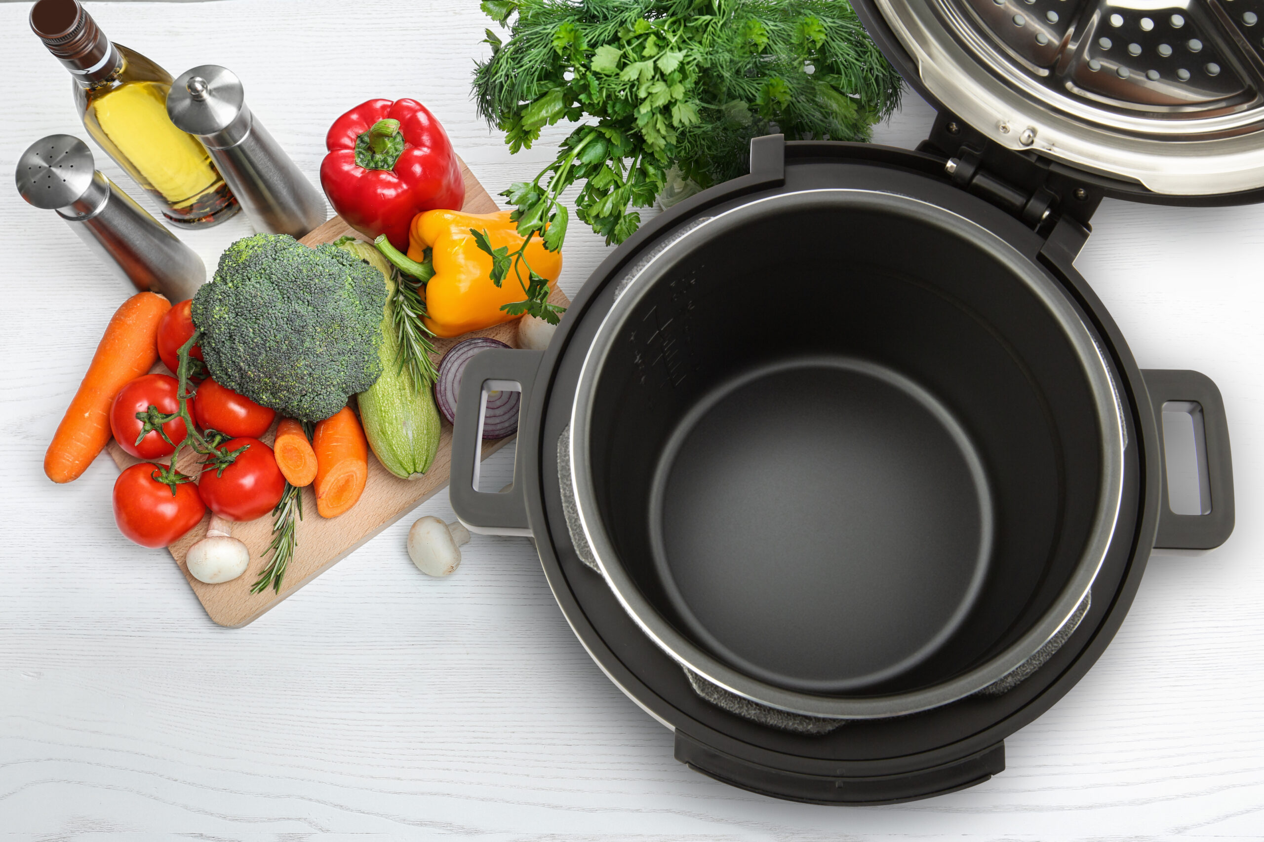 Modern multi cooker and products on white wooden table, flat lay